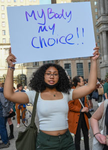 Photo of a woman holding a sign reading My Body My Choice